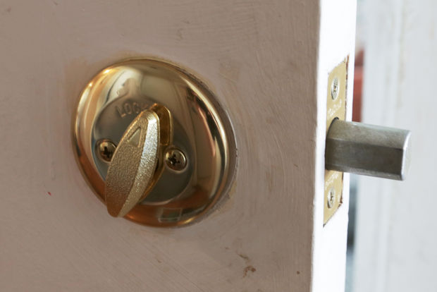 Close-up of a locksmith unlocking and installing a home deadbolt lock