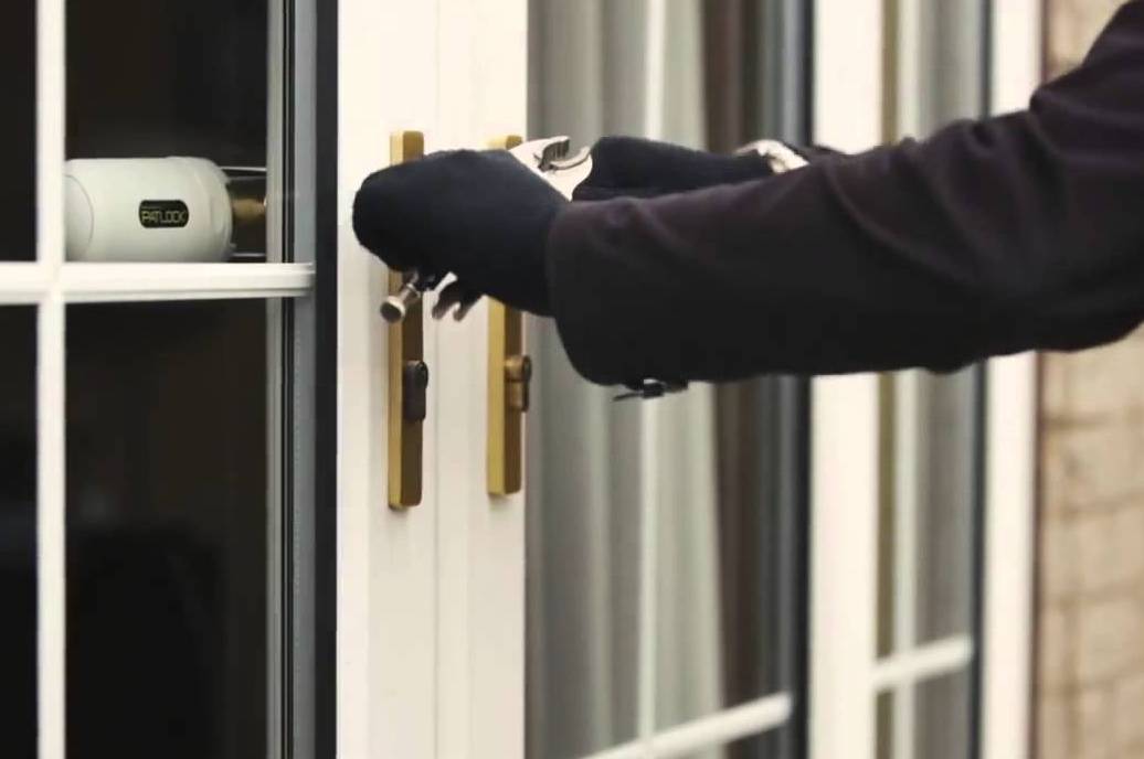 Locksmith servicing the lock mechanism on a commercial glass office door