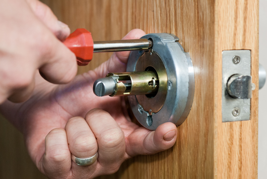 Locksmith installing a new high-security deadbolt lock on a home door in Kuala Lumpur