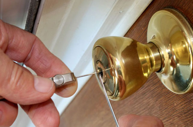 Professional locksmith using picks to unlock a residential door without causing damage